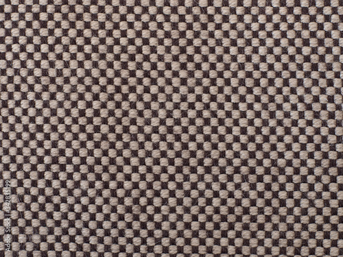 brown, light and dark checkered material with visible texture. background or texture, closeup.