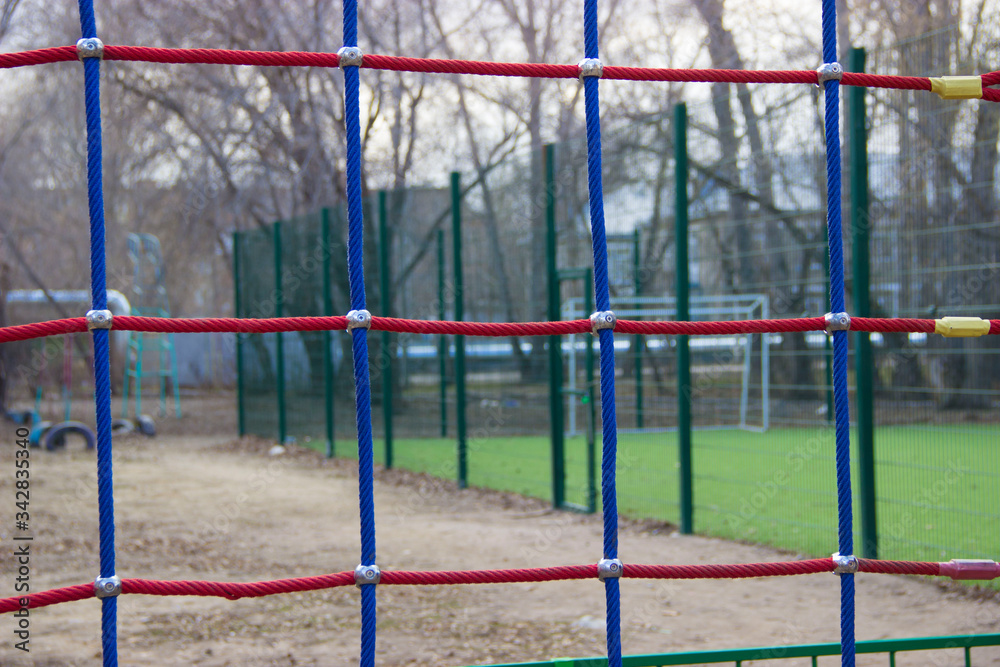 
Grid multi-colored in the background a football square fenced with a metal mesh
