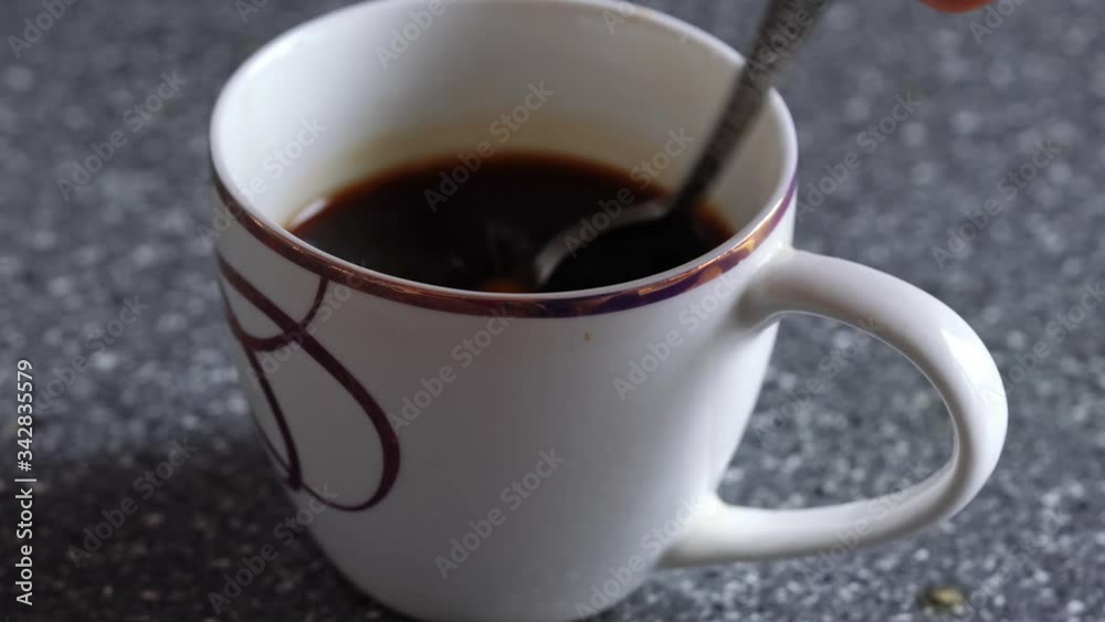 male hand with a spoon stirs coffee with lemon male hand with a spoon stirs coffee with lemon