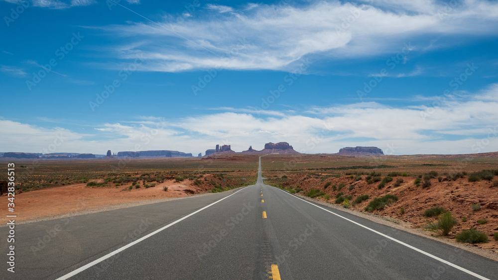 Weitsicht auf das Monument Valley von einer endlos langen Straße