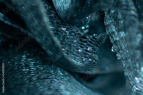 Background and backsplash of wet net with moist crystal water drops stuck between strings - abstract structure, technology, design, london blue topaz macro