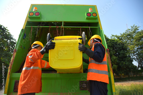 Garbage collector Worker of urban municipal recycling garbage collector truck loading waste and trash bin photo