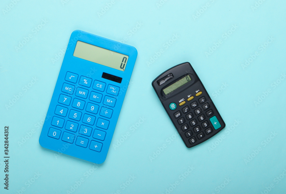 Two calculators on blue background. Top view. Two calculators on blue background. Top view.