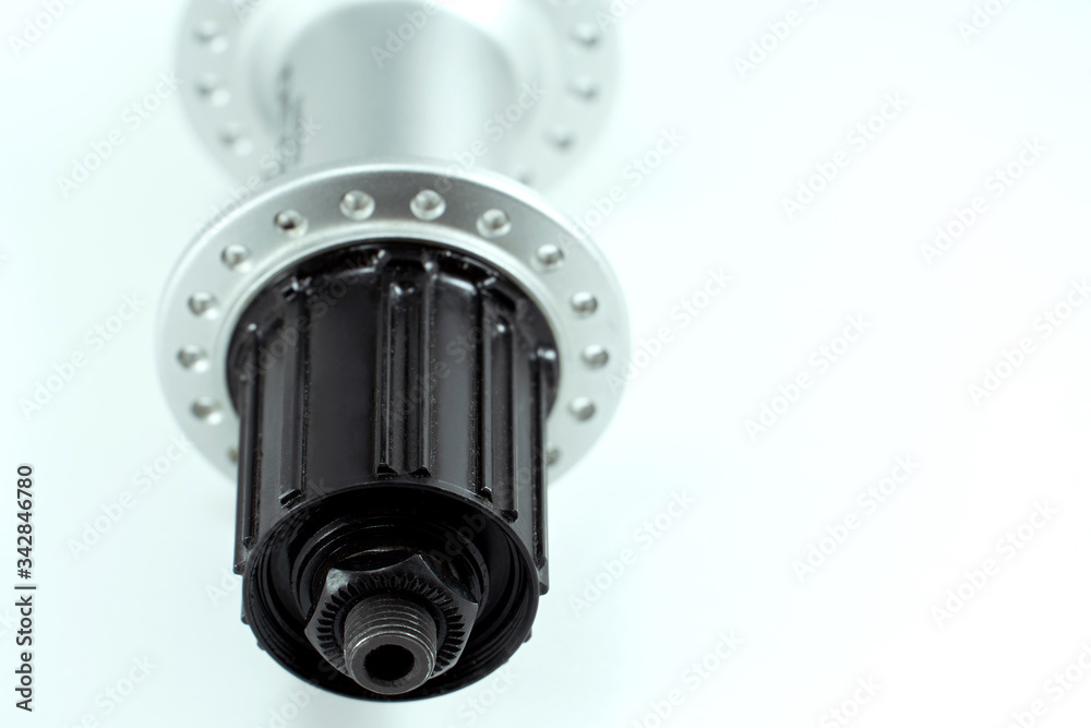 Bicycle repair. Mountain bike workshop. Rear hub under the disc brake on a white background. The body is silver. Spare parts for a bicycle of a famous manufacturer and brand. Bicycle repair. Mountain bike workshop. Rear hub under the disc brake on a white background. The body is silver. Spare parts for a bicycle of a famous manufacturer and brand.