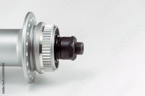 Bicycle repair. Mountain bike workshop. Rear hub under the disc brake on a white background. The body is silver. Spare parts for a bicycle of a famous manufacturer and brand.