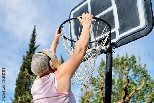 older woman with music headphones playing basketball