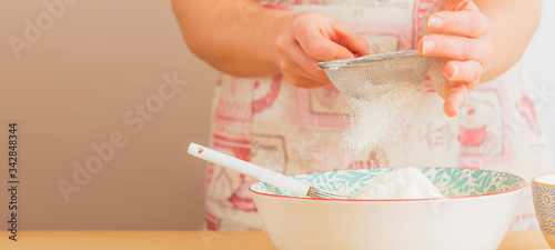 Tableau sur toile chica pastelera tamizando harina en un bol de colores, espacio de copia
