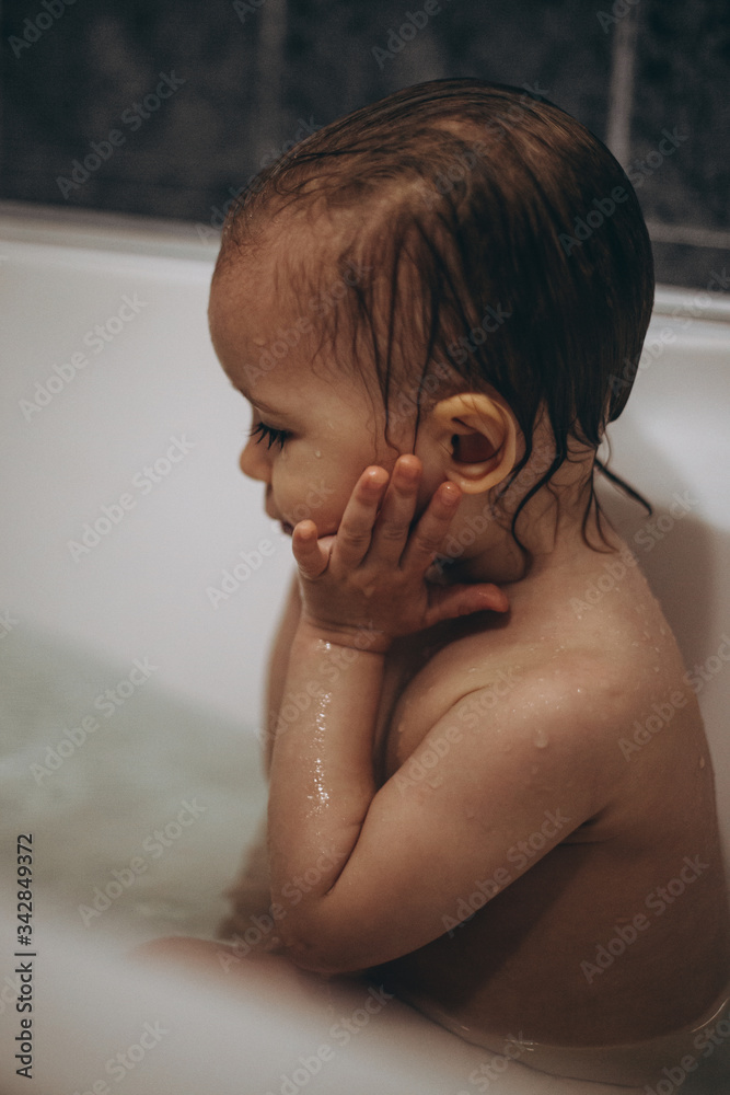 selective focus, noise effect: family is washing and bathing the baby in the bathroom, child girl have fun, she is happy and smiling, likes to enjoy water selective focus, noise effect: family is washing and bathing the baby in the bathroom, child girl have fun, she is happy and smiling, likes to enjoy water