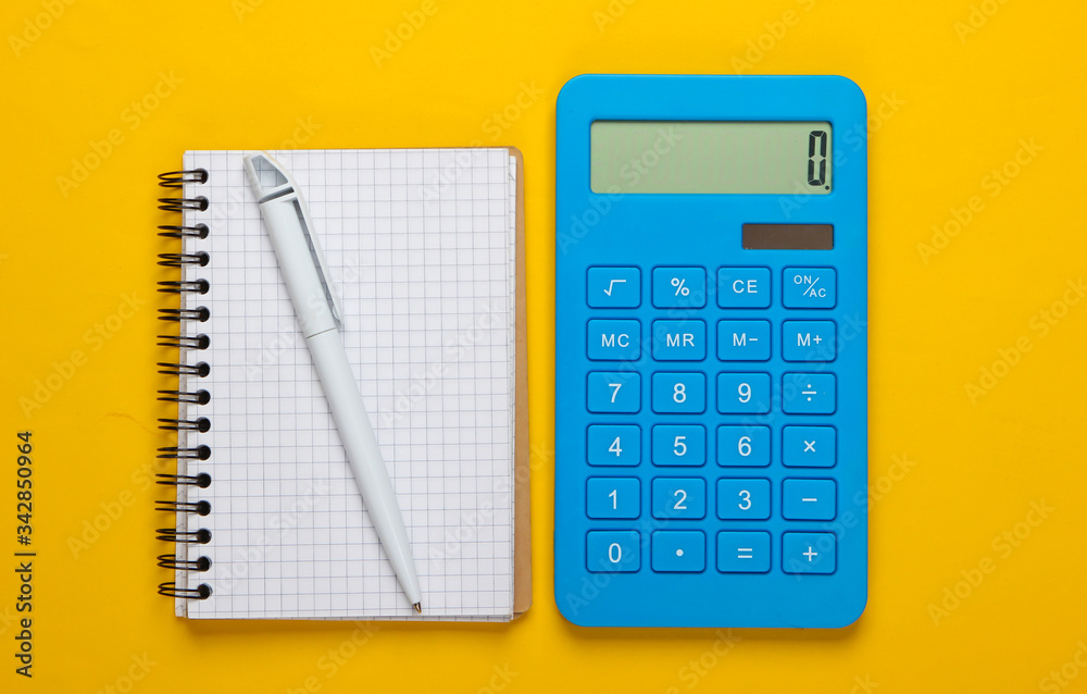 Calculator with notebook on yellow background. Education process. Top view. Flat lay Calculator with notebook on yellow background. Education process. Top view. Flat lay