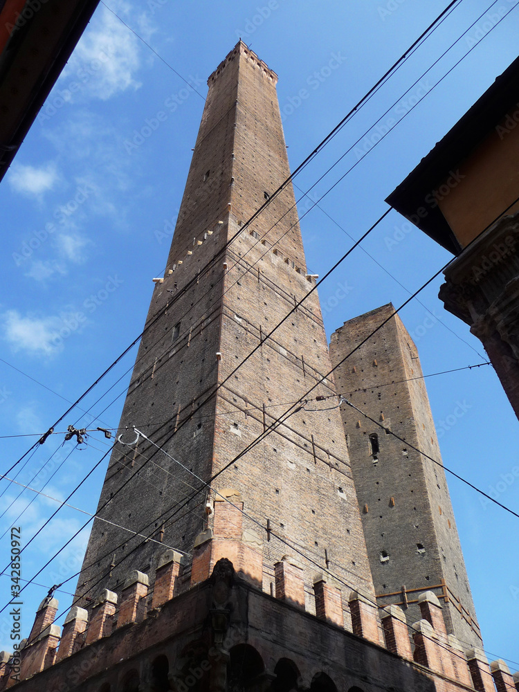 Leaning towers of Asinelli and Garisenda behind the tram cables . City of Bologna. Italy.