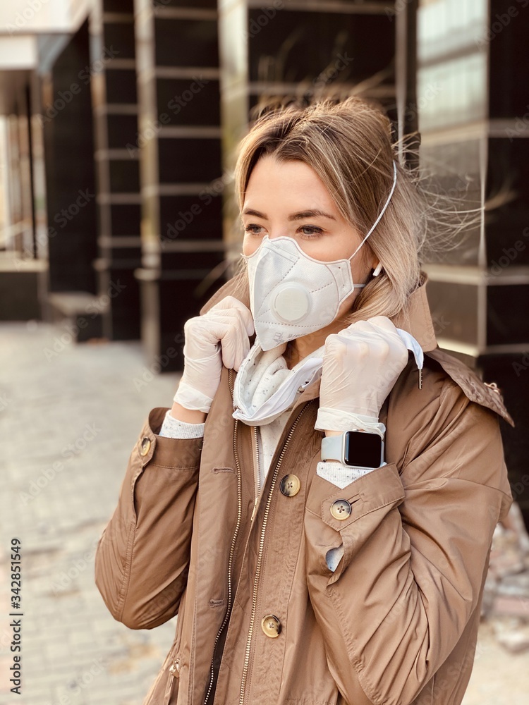 Stylish young woman with flu mask and protective gloves against coronavirus. Covid-19. smart watch on a girl’s hand. Stylish young woman with flu mask and protective gloves against coronavirus. Covid-19. smart watch on a girl’s hand.