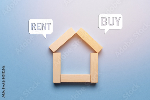Concept of renting or buying real estate house made of wooden blocks with icons.
