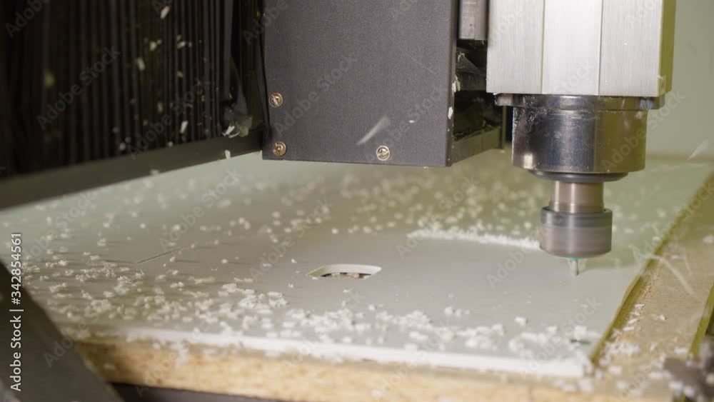 Milling machine cut letters of white plastic canvas. Production of the adv sign