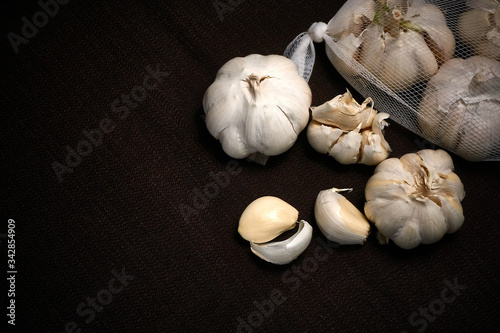 Bulbil, head and net of garlic on a dark background