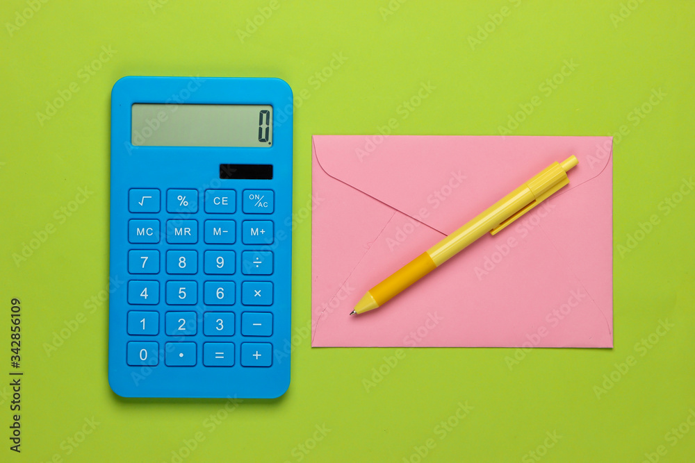 Calculator with envelope on green background. Top view Calculator with envelope on green background. Top view