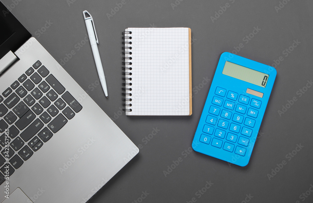Calculator with notebook and laptop on gray background. family budget management. Top view Calculator with notebook and laptop on gray background. family budget management. Top view