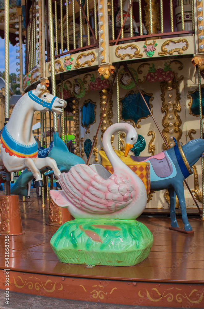 Colorful merry-go-round with animal figures. Empty vintage carousel in park. Retro roundabout. Fairground carousel.Childhood concept. Summertime fun. Festival carnival. Outdoor circus concept.