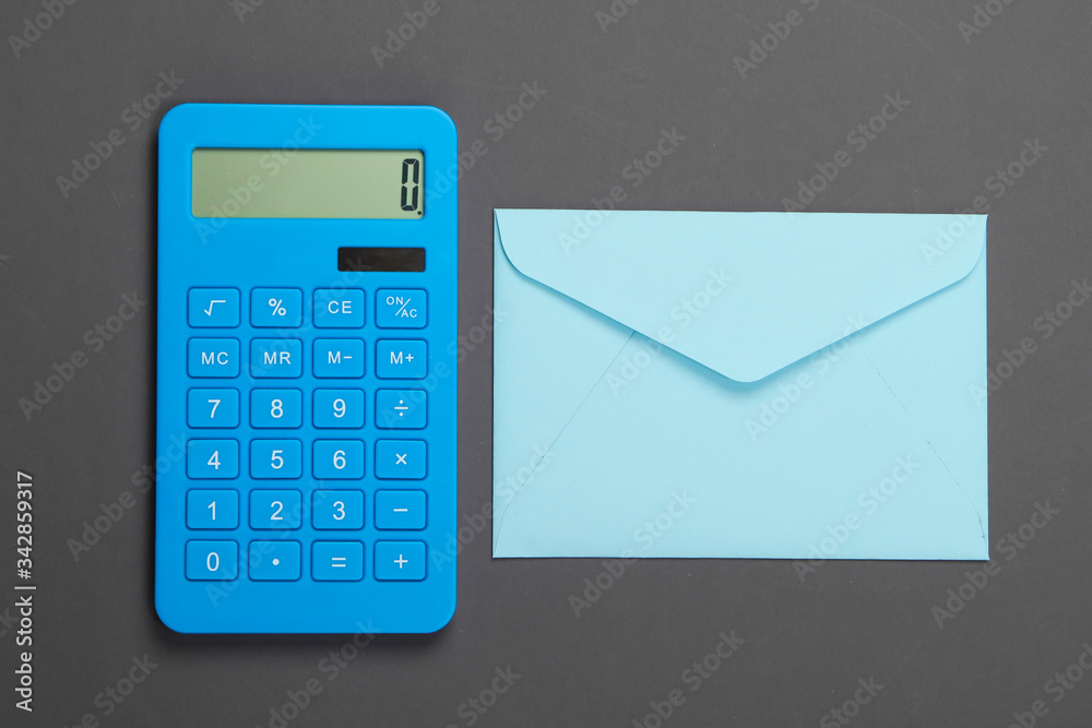 Calculator with envelope on gray background. Top view Calculator with envelope on gray background. Top view