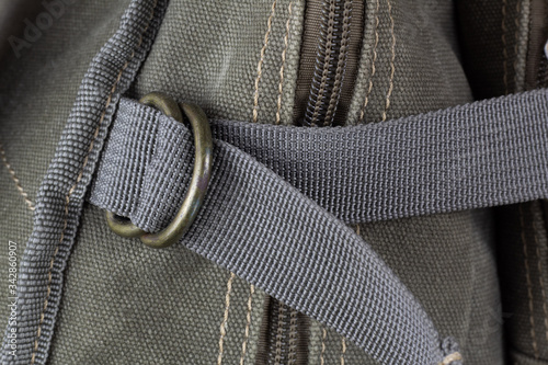 Fragment of a textile backpack with zippers and zippers. Textured pattern of coarse interwoven threads.