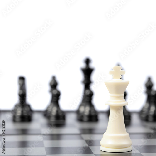 Chess pieces on the chessboard on white background. Closeup of some chess figures. Copy space