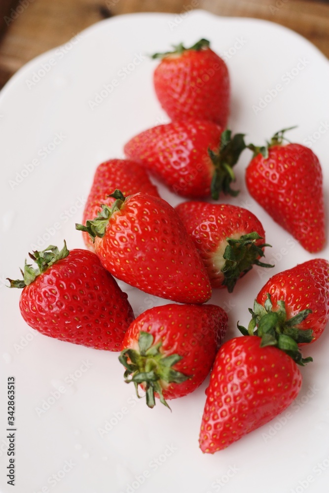 Juicy strawberries in a white plate on the table Juicy strawberries in a white plate on the table