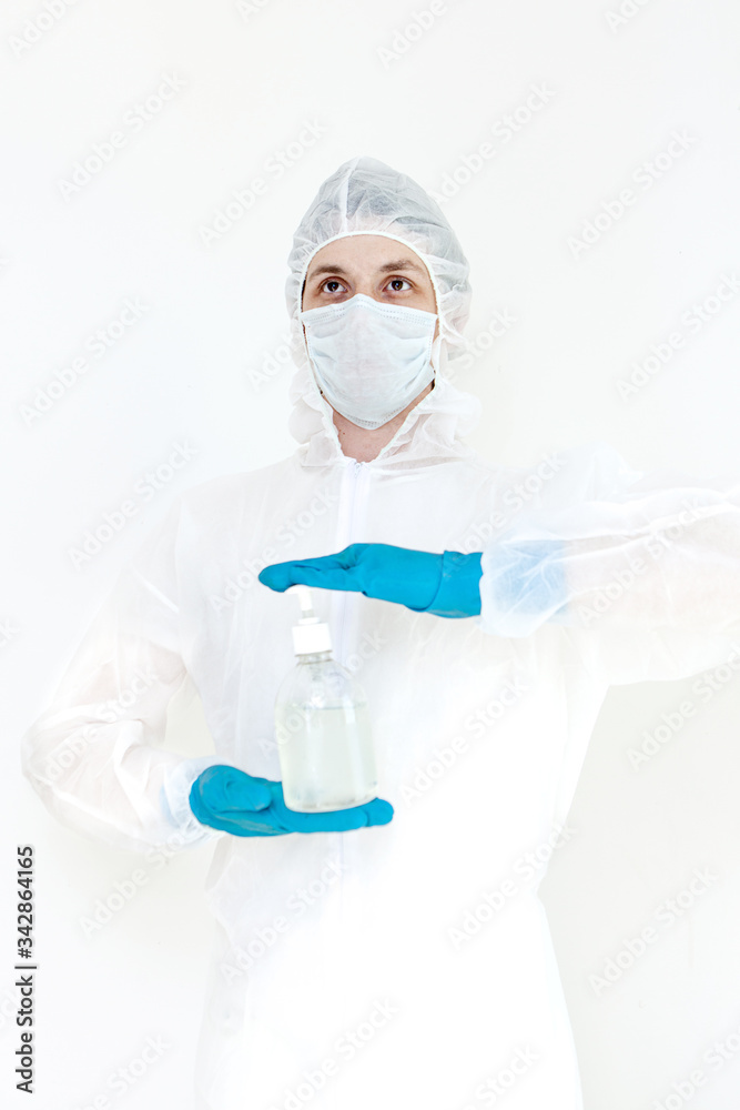 A man in a protective suit holds an antibacterial antiseptic gel for hand disinfection. Health care prevention during an outbreak of the flu virus and a coronavirus epidemic A man in a protective suit holds an antibacterial antiseptic gel for hand disinfection. Health care prevention during an outbreak of the flu virus and a coronavirus epidemic