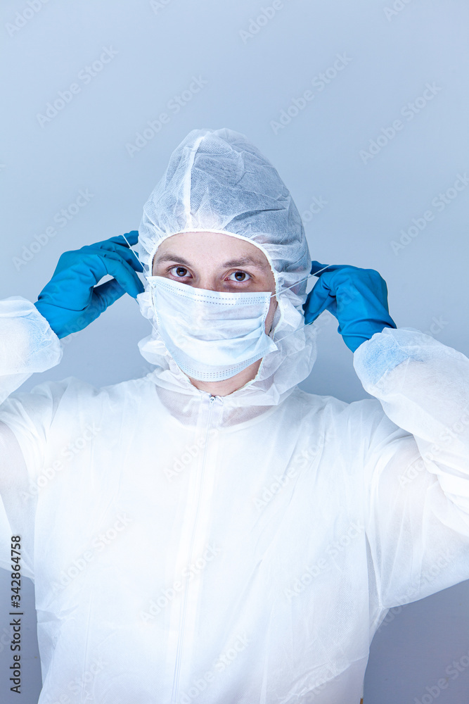 a man in a protective suit, gloves and puts a mask on his face. The concept of health care.