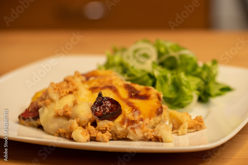 Mashed potatoes baked with meat with lettuce salad on side