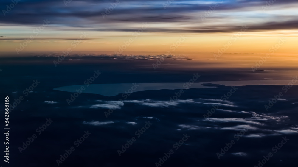 Fototapeta premium Lake Balaton from an aerial view, with soft clouds, yellow sunset, and distant Hungarian lands, cities. 