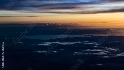 Lake Balaton from an aerial view  with soft clouds  yellow sunset  and distant Hungarian lands  cities. 