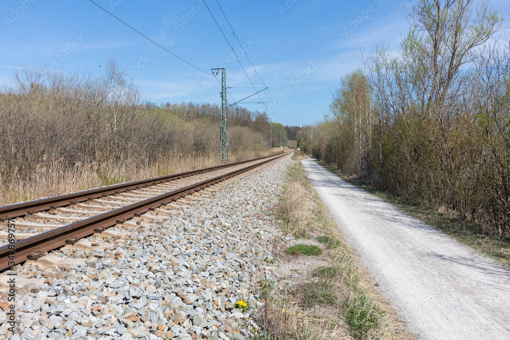 Straight view along a footpath and railway tracks Straight view along a footpath and railway tracks