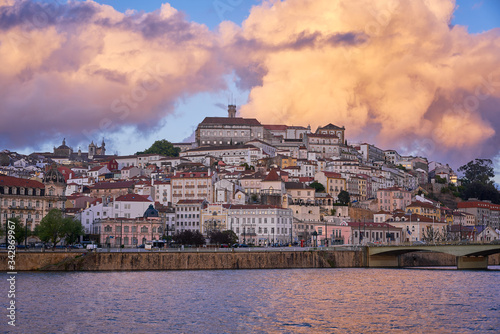 Coimbra city view at sunset with Mondego river and beautiful historic buildings, in Portugal