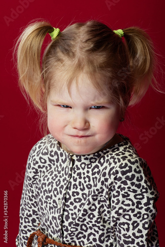 portrait of a little girl with bright facial expressions, she is angry and pouting