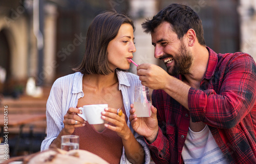 Attractive smiling couple drinking coffee and have fun