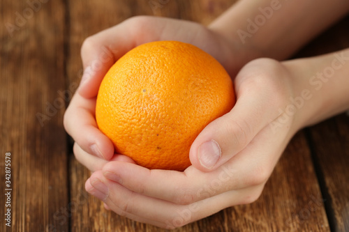 orange in the hands of a man

