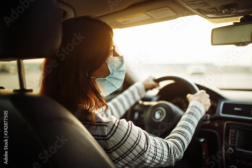 Woman car driver rides wearing medical sterile mask during pandemic coronavirus quarantine. Transport isolation to stop spread of virus of covid-19. Healthcare concept. © Konstantin Zibert