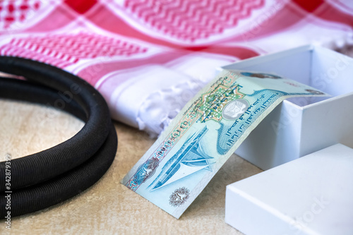 Close-up Set of arab scarf shawl keffiyeh or kafiya, iAgal, arabian banknotes UAE Dirhams in Gift box.