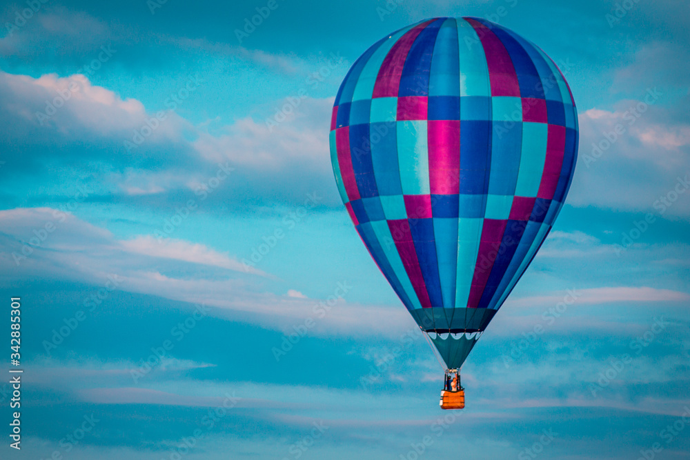 Fototapeta premium Hot air balloon floating by during a beautiful sunset in the summer in Michigan