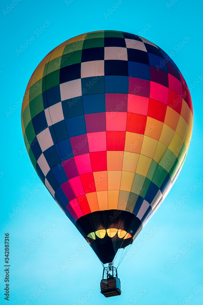 Naklejka premium Rainbow hot air balloon flying through the sky in Michigan