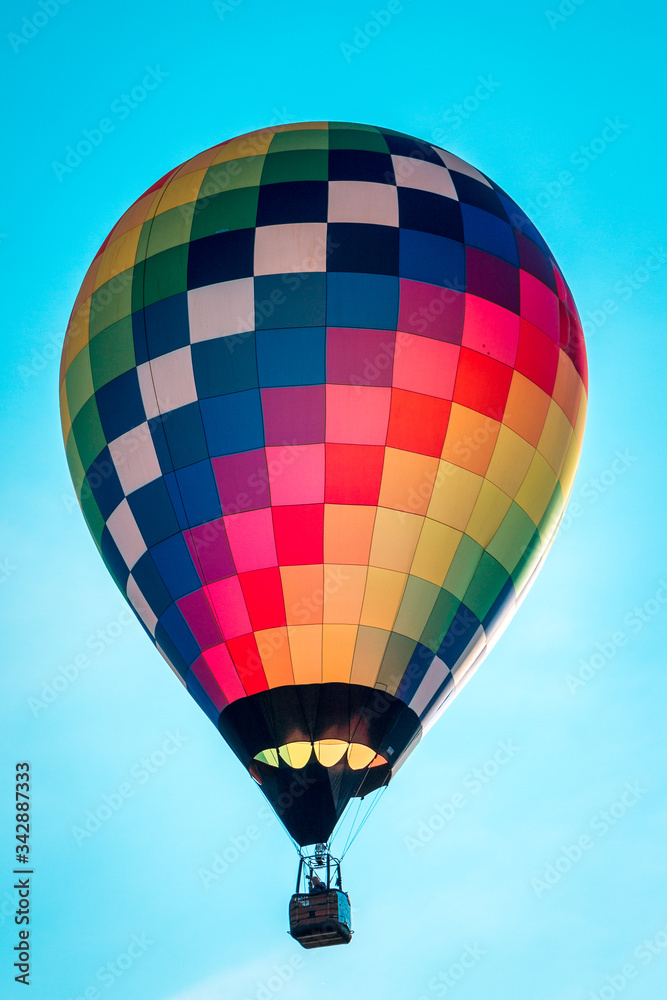 Naklejka premium Rainbow hot air balloon flying through the sky