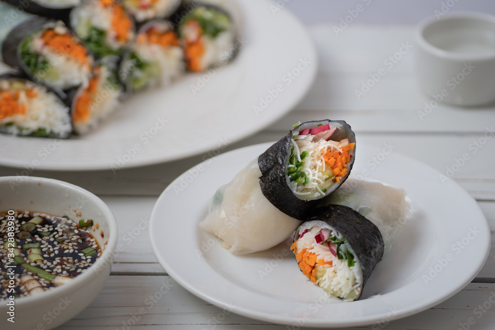 Vietnamese vegan rice paper and nori sheet spring rolls on white plate