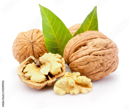 Kernel and whole walnuts with leaves isolated on white background photo