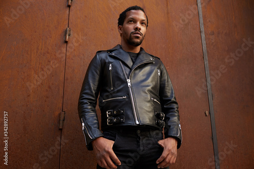 Outdoor portrait of young African man wearing biker leather jacket. Handsome and confident.  © face_reader_img