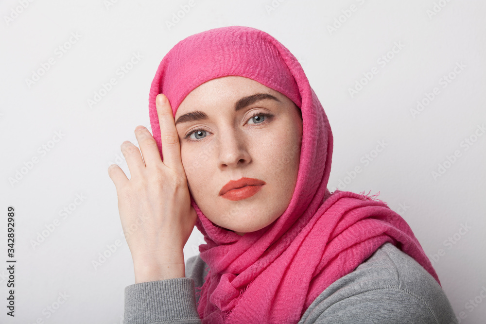 Close-up portrait of a muslim woman wearing a head scarf hijab and smilling. Isolated.