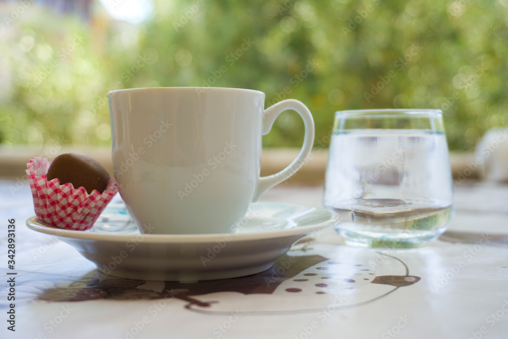Turkish Coffee, sweet cookies and water on table. Low view composition. Closeup shot of hot Greek Coffee. Beautiful delicious tasty traditional brown drink of Turkish culture. Enjoy concept photo Turkish Coffee, sweet cookies and water on table. Low view composition. Closeup shot of hot Greek Coffee. Beautiful delicious tasty traditional brown drink of Turkish culture. Enjoy concept photo