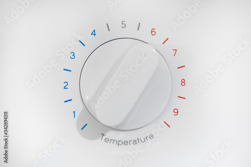 Thermostat with nine levels of temperature regulation, blue cold zone and red hot, white dial on 6 position, isolated on white background.