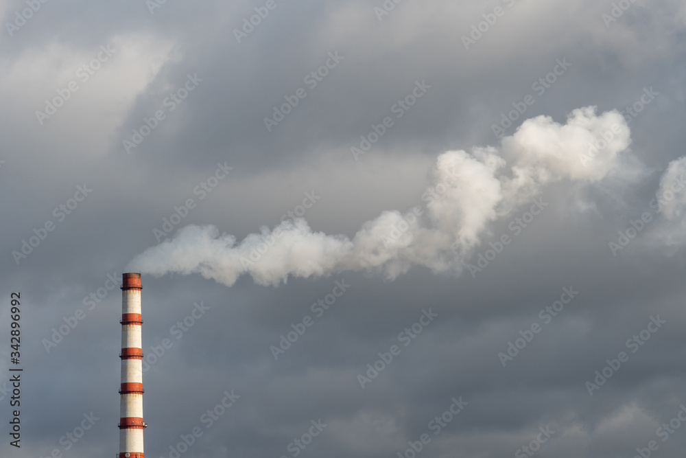 the smoke from the power plant chimney. Environmental pollution. non-renewable energy sources.  Large chimney against a background of grey clouds. Environmental disaster.