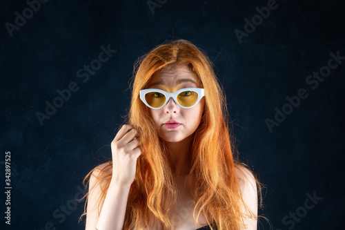 Beauty portrait of young adorable red-haired woman with bare shoulders.