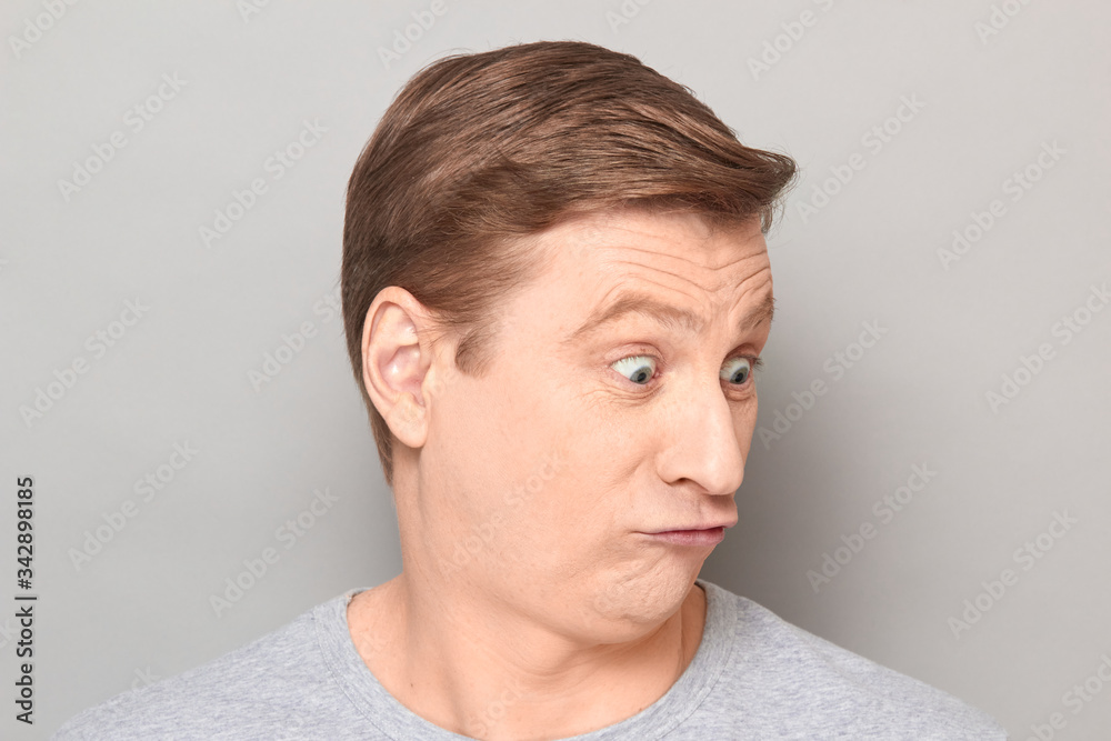 Portrait of blond mature man with fool goofy perplexed expression