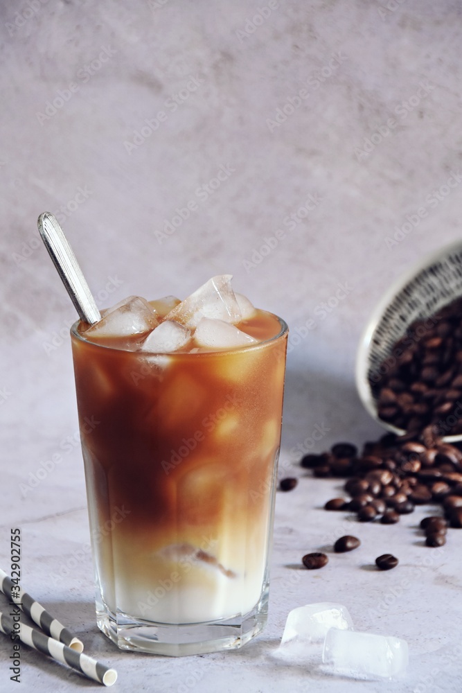 Iced coffee drink in a glass on the light background Iced coffee drink in a glass on the light background